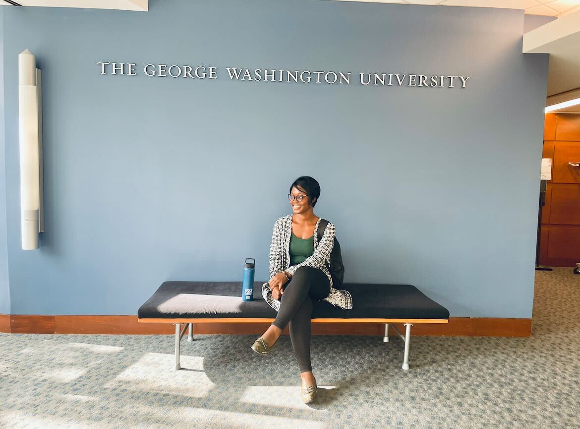 Beverly sits on a bench in the SMPA building at George Washington University